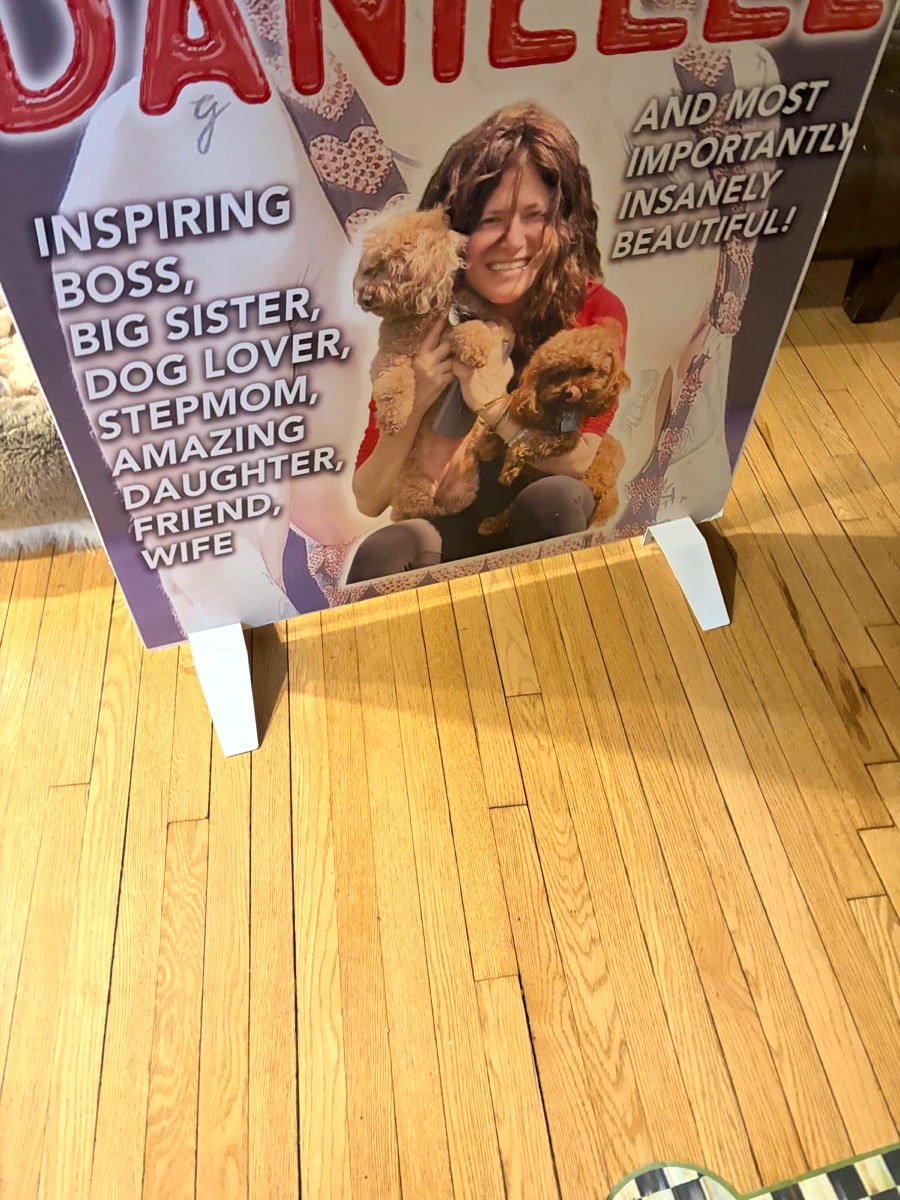 A foam-board print standing on a display stand on a wood floor
